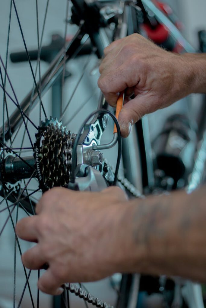 pexels photo 10263879 Detailed image of hands performing maintenance on a bicycle gear using tools.
