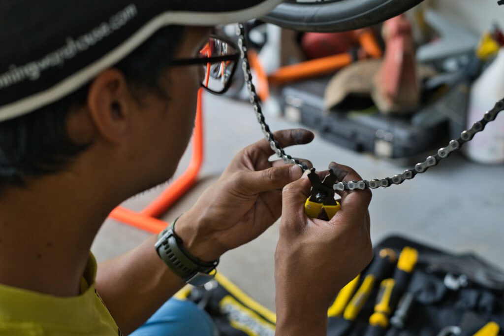 pexels photo 13122870 Close-up of a mechanic working on a bicycle chain inside a workshop, showcasing precision and manual skill.