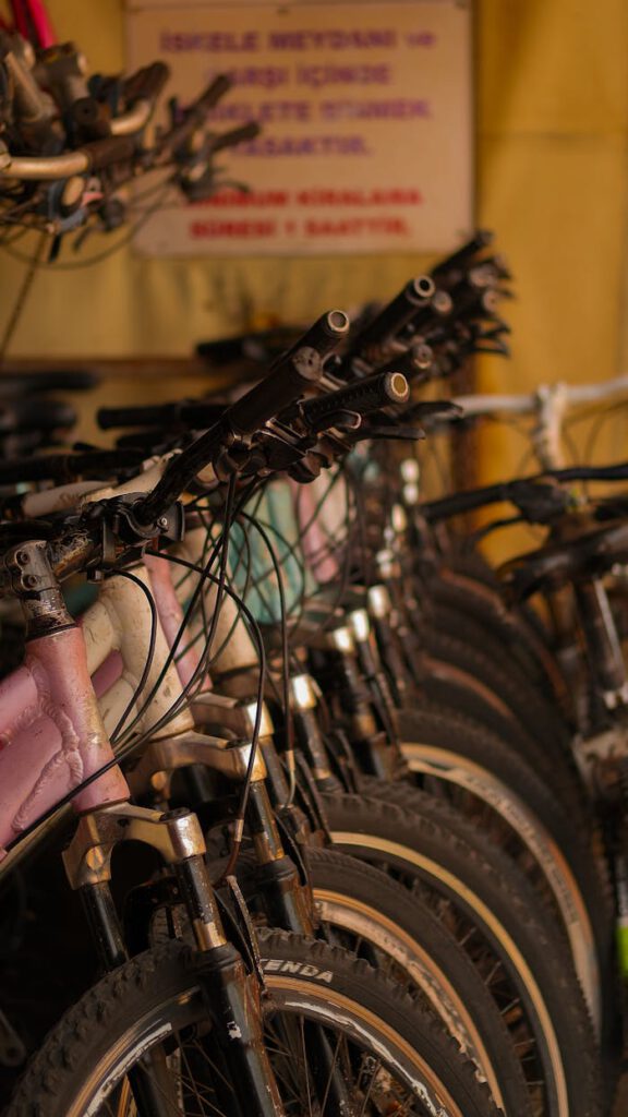 Close-up of vintage bicycles with rusty handlebars in a dimly lit space.